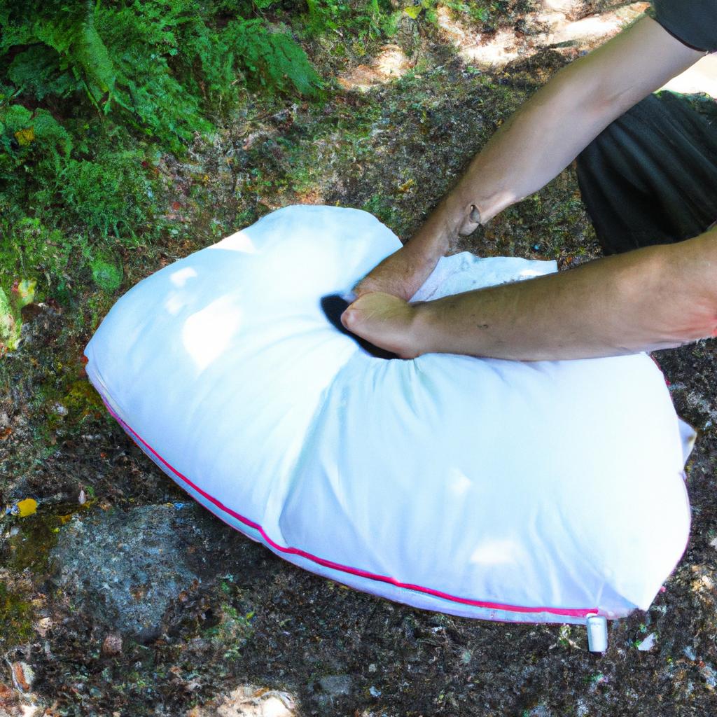 Person inflating camping pillow outdoors